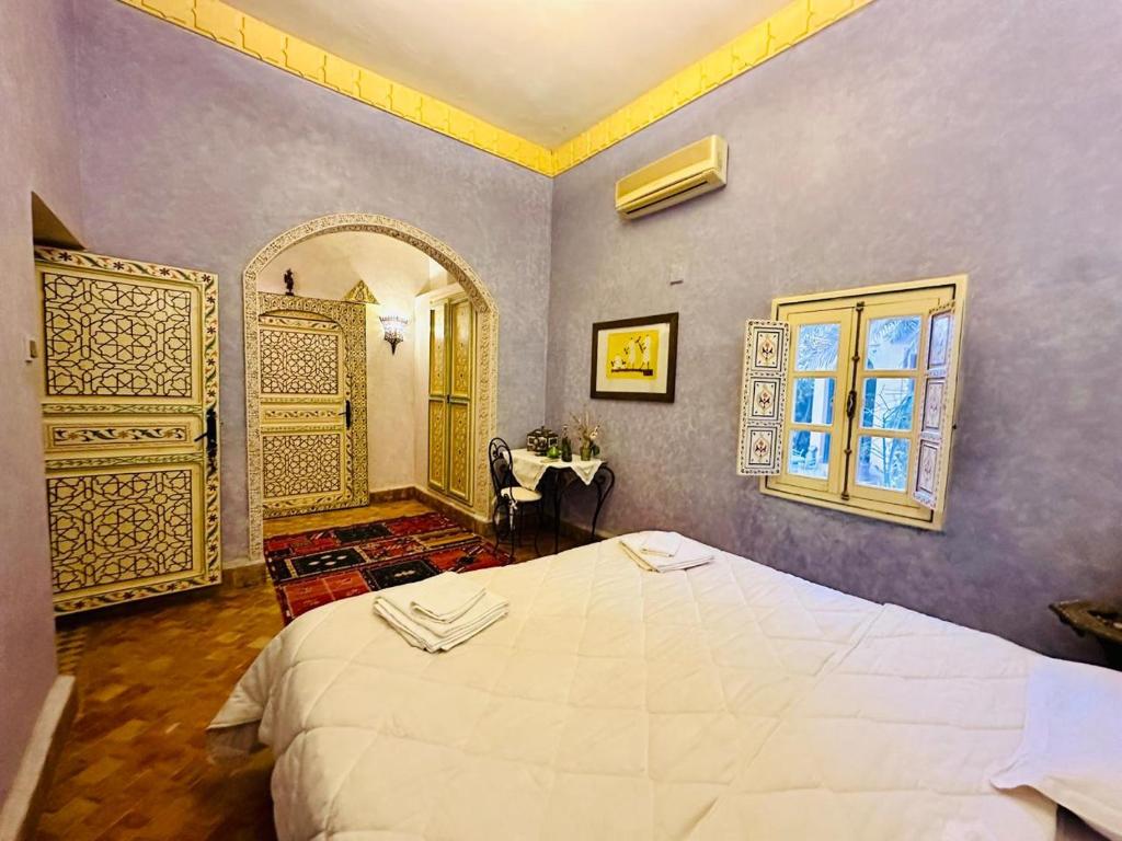 a bedroom with a large white bed and a window at Ksar Jenna in Nkob