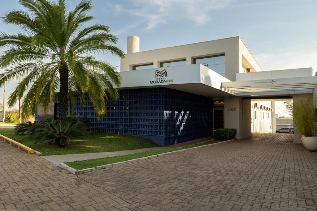 ein Gebäude mit einer Palme davor in der Unterkunft Morada Inn Hotel in Franca