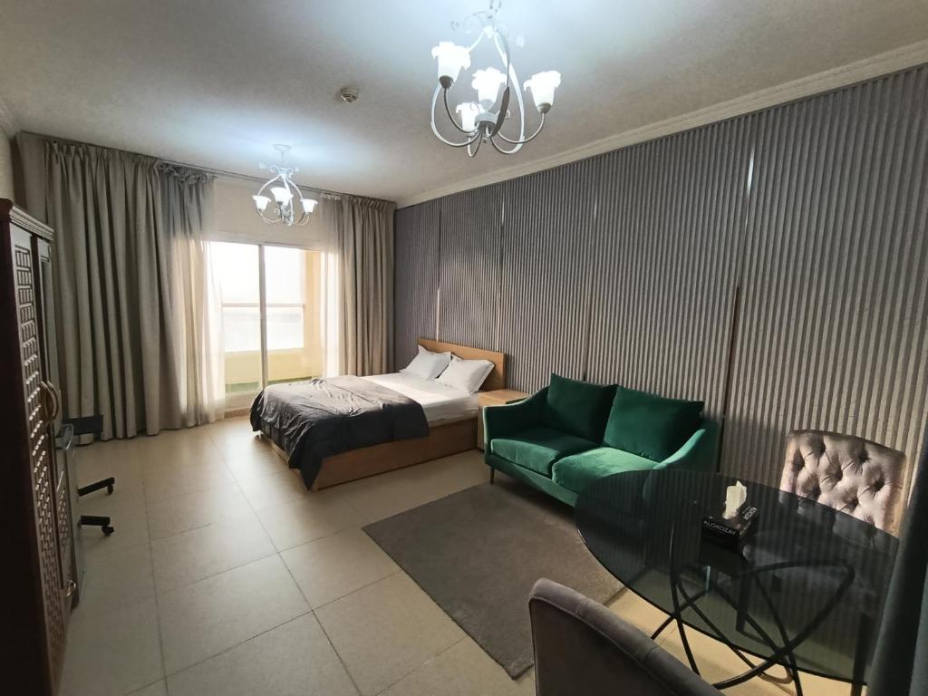 a hotel room with a bed and a green couch at ApartHotel Rooms in Ajman 