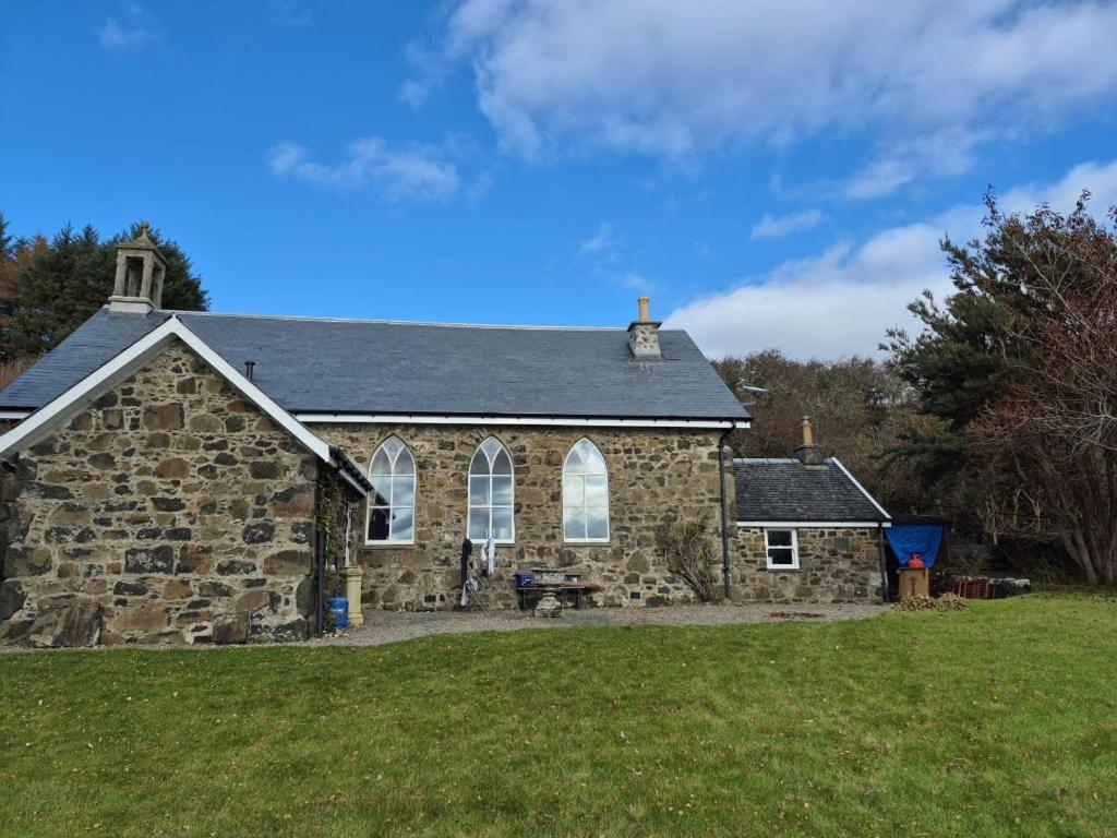 an old stone church with a grass field at Kilfinichen Church in Kilfinchen