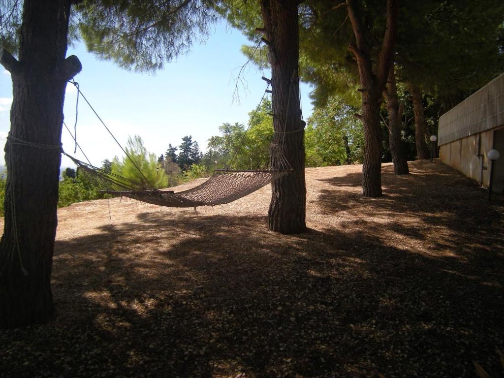 a hammock hanging between two trees in a park at Appartamento La Pinetina in Valderice
