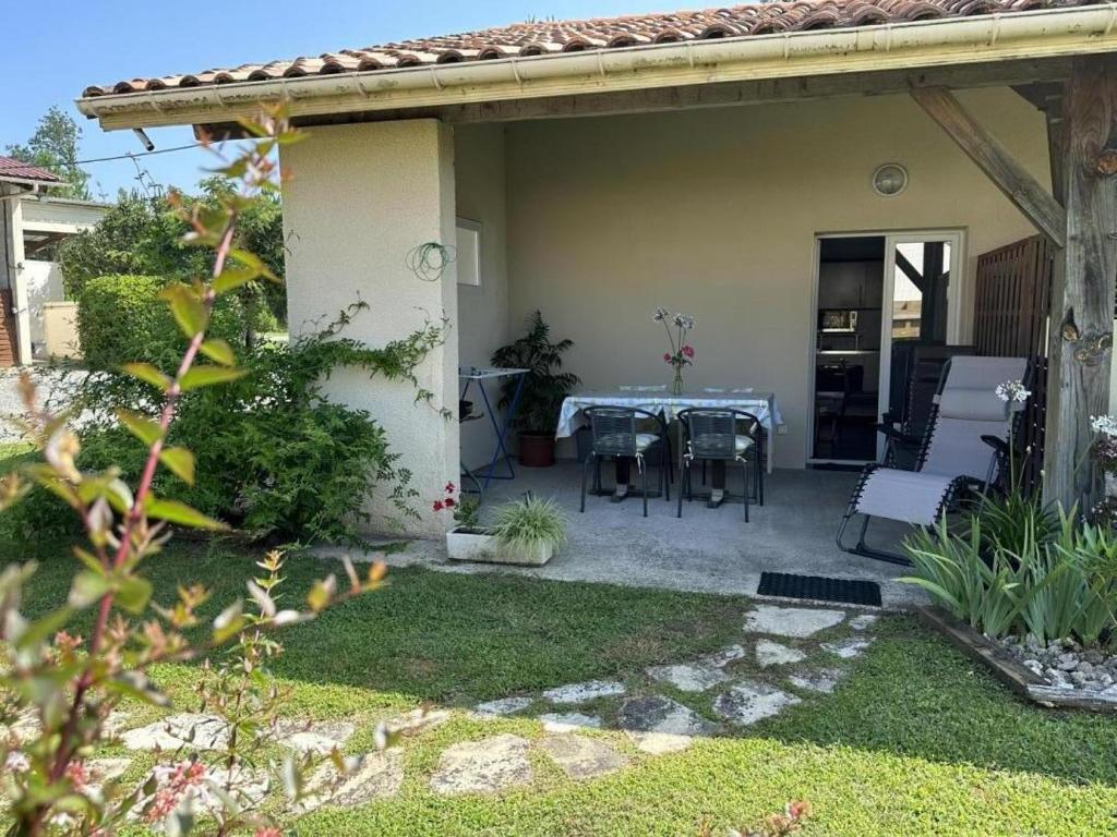 a patio with a table and chairs in a yard at La lande in Pontonx-sur-lʼAdour