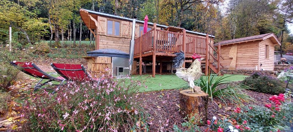 Anglure-sous-DunにあるRoulotte Le Coq La Mazilleの小屋の前の切り株の上に立っている鶏