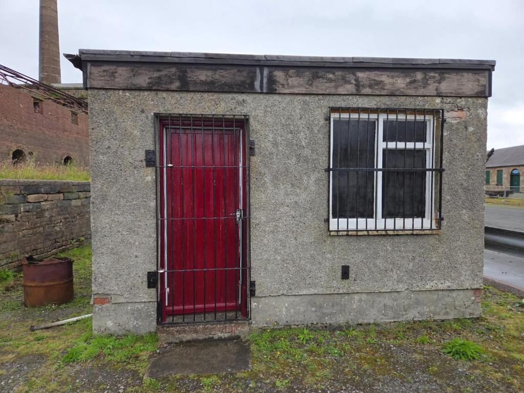 PatnaにあるThe Bunkhouseの2つの窓がある建物の側面にある赤いドア