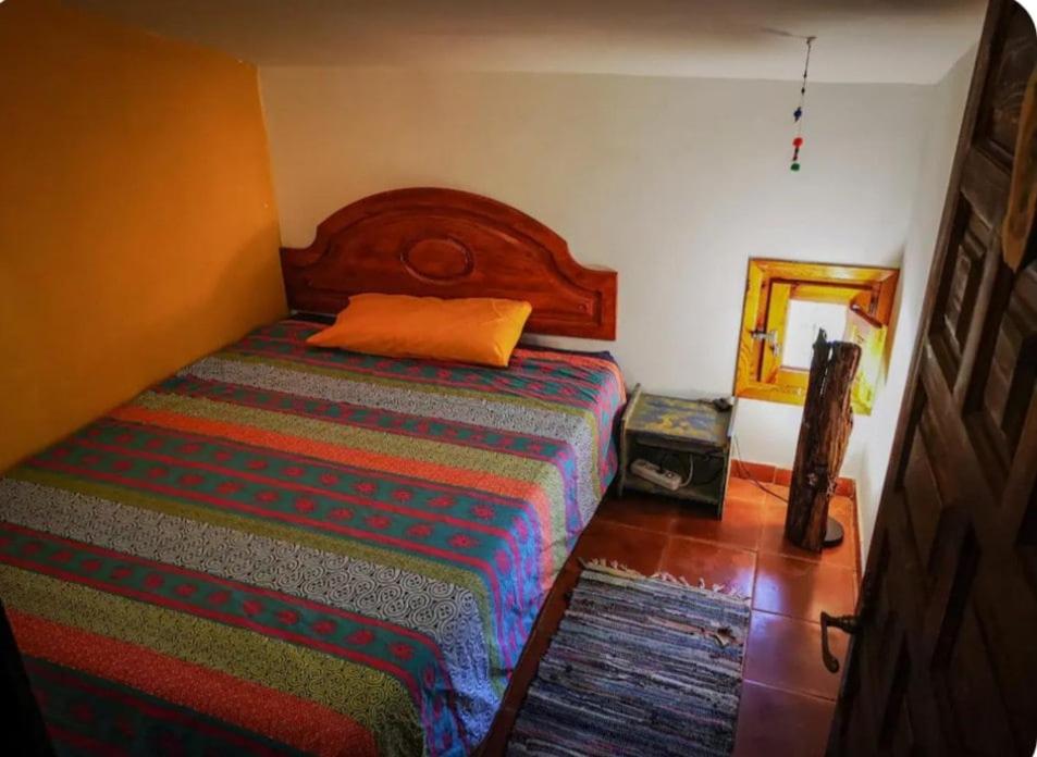 een slaapkamer met een bed met een houten hoofdeinde en een spiegel bij DonPepo Guesthouse in Torres de Albarracín