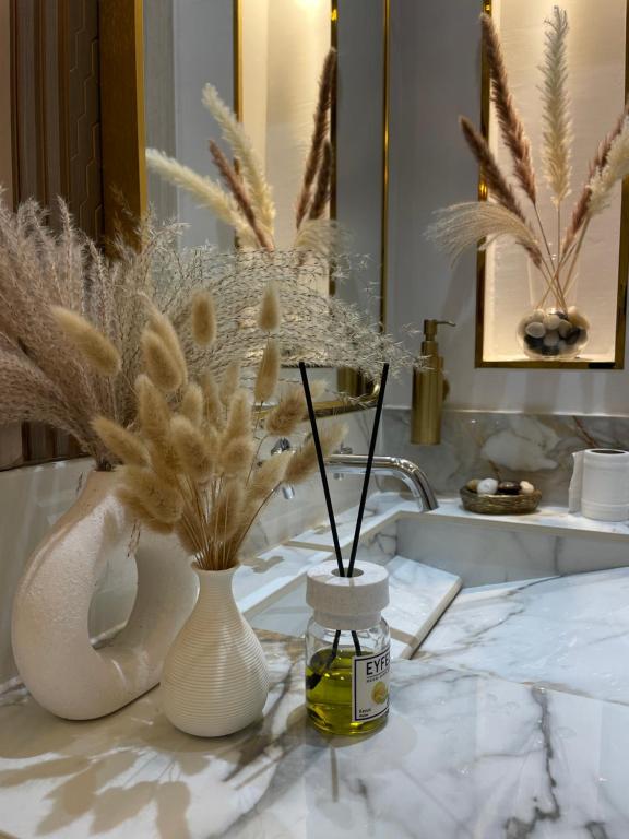 a bathroom with two vases and a bottle of perfume at شاليه هوانا in Sohar