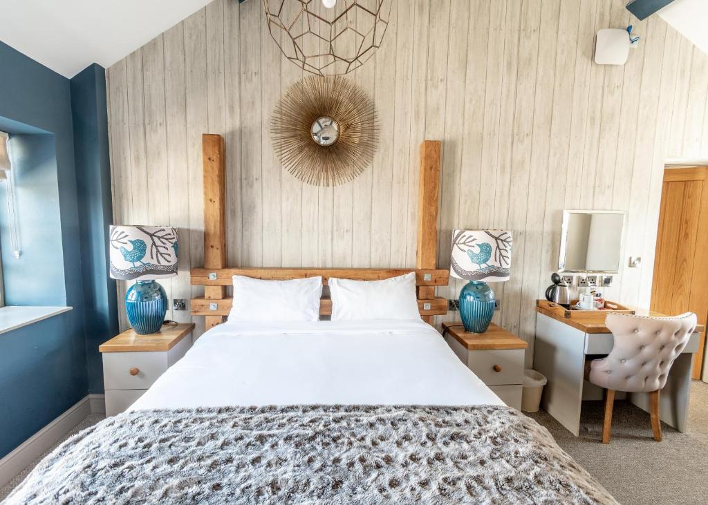 Un dormitorio con una cama grande y un escritorio. en Wheatsheaf Inn, Bar Hill, en Onneley