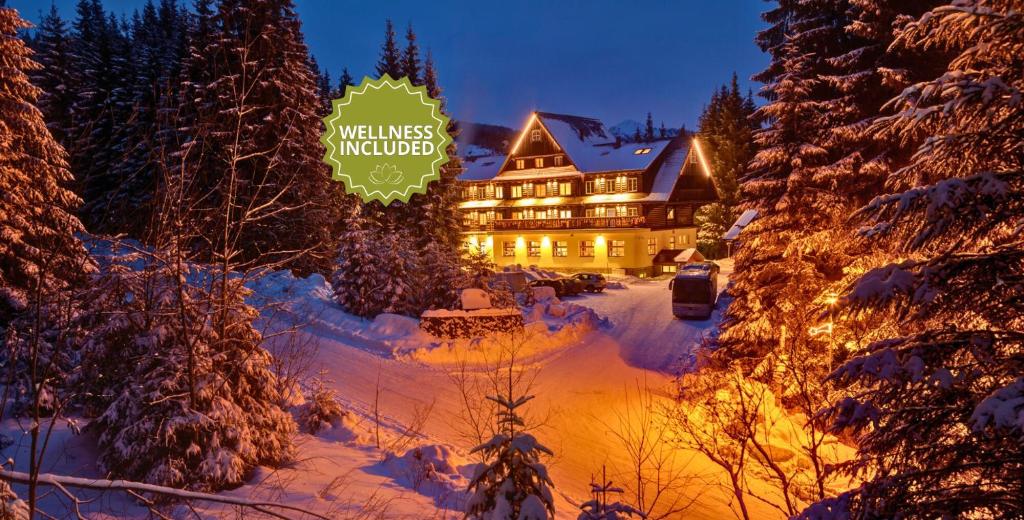 a large building with a sign in the snow at Hotel Mikulášska Chata in Belá