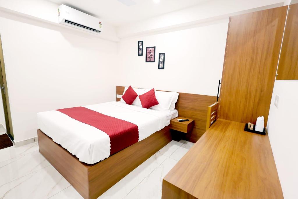 een slaapkamer met een bed met een rood-witte deken bij Hotel Arctic Gold in Cochin