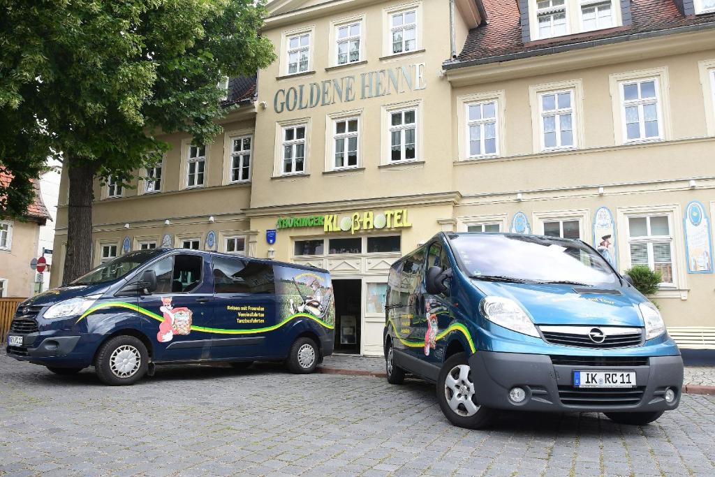 zwei kleine Autos, die vor einem Gebäude geparkt sind in der Unterkunft Hotel garni Goldene Henne in Arnstadt