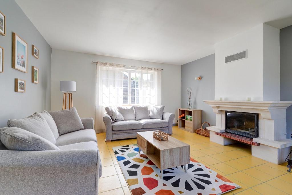 a living room with two couches and a fireplace at L'Orée du Bois - Avec Jardin in Rouvroy-sur-Serre