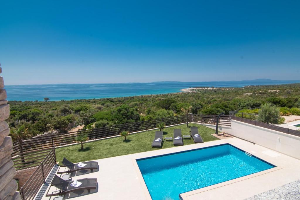 a villa with a swimming pool and the ocean at Villas Royal III in Novalja