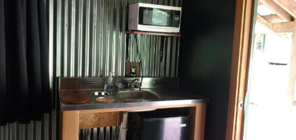 a kitchen with a sink and a microwave at Relaxing Group Cabin with Fire Ring in Indiana in Stony Lonesome