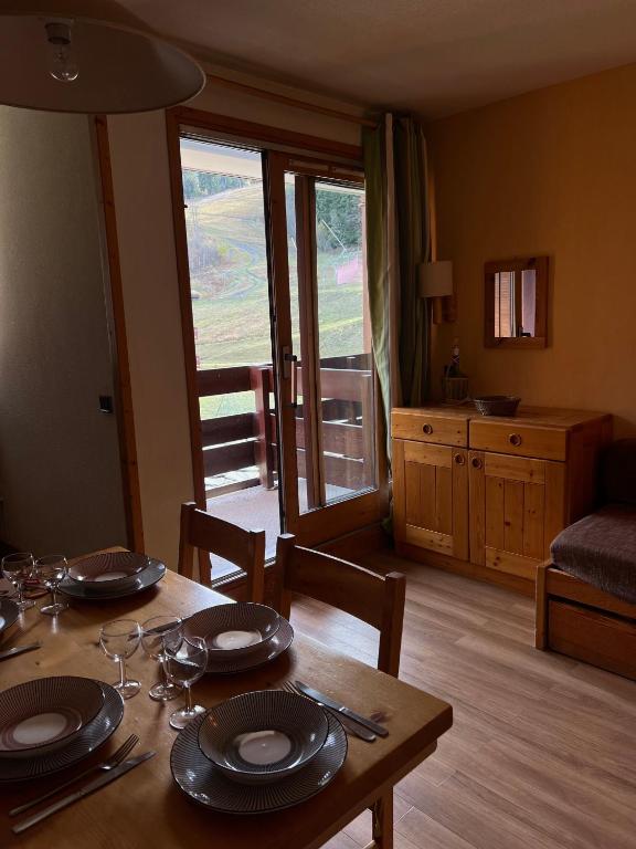 a dining room with a table and a living room at Les Traverses 18 in Valmorel