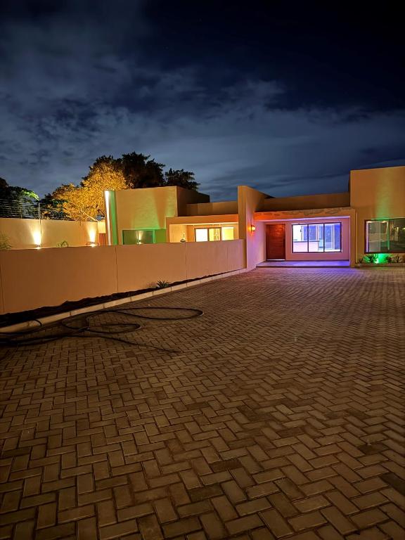 a house with a brick driveway in front of it at night at VIP Djuba Guest in Fombeni