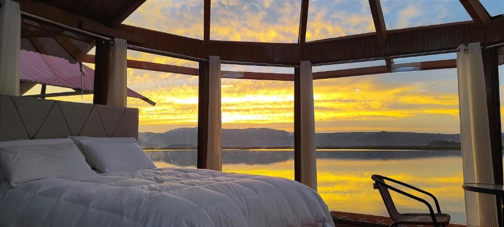 a bedroom with a bed and a view of the water at Meytic Titicaca lodge Uros in Puno