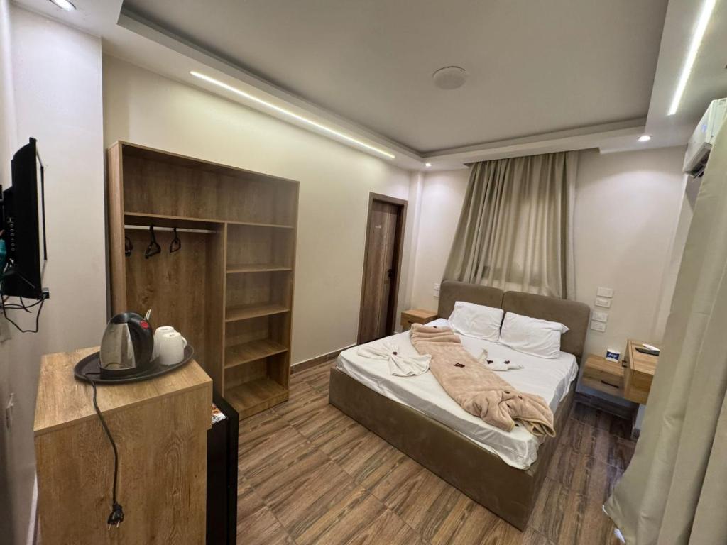 una habitación de hotel con una cama y un televisor en ArQa pyramids Hotel, en El Cairo