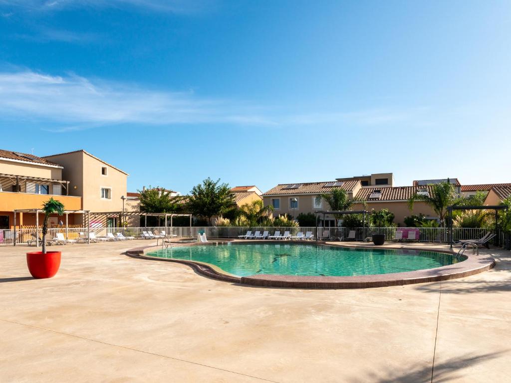 a swimming pool in the middle of a courtyard at Vacancéole - Les Demeures Torrellanes - Saint-Cyprien in Saint-Cyprien