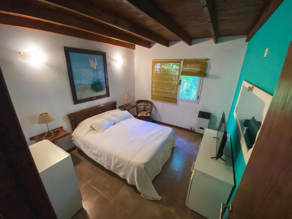 ein Schlafzimmer mit einem Bett und einem Fernseher darin in der Unterkunft La Unión in Mar Azul