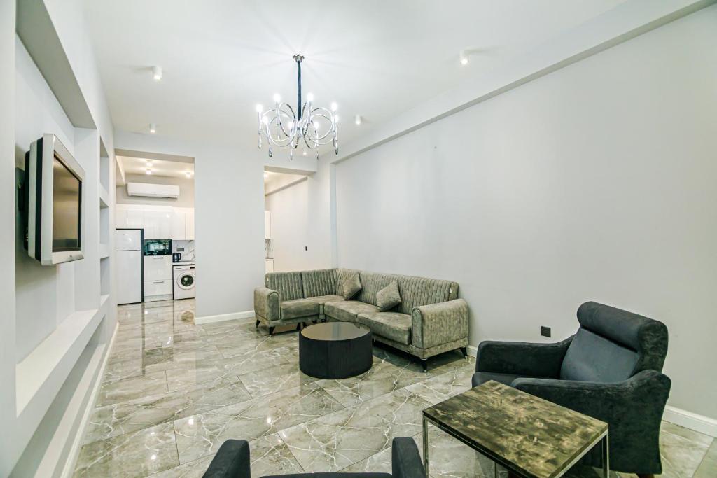 a living room with two couches and a chandelier at Lux Apartment View Baku Formula 1 Street in Baku
