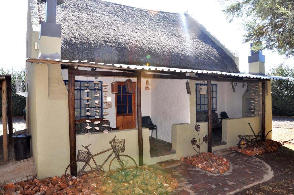 a small house with a bicycle outside of it at Blou Windpomp Guest Lodge in Delmas