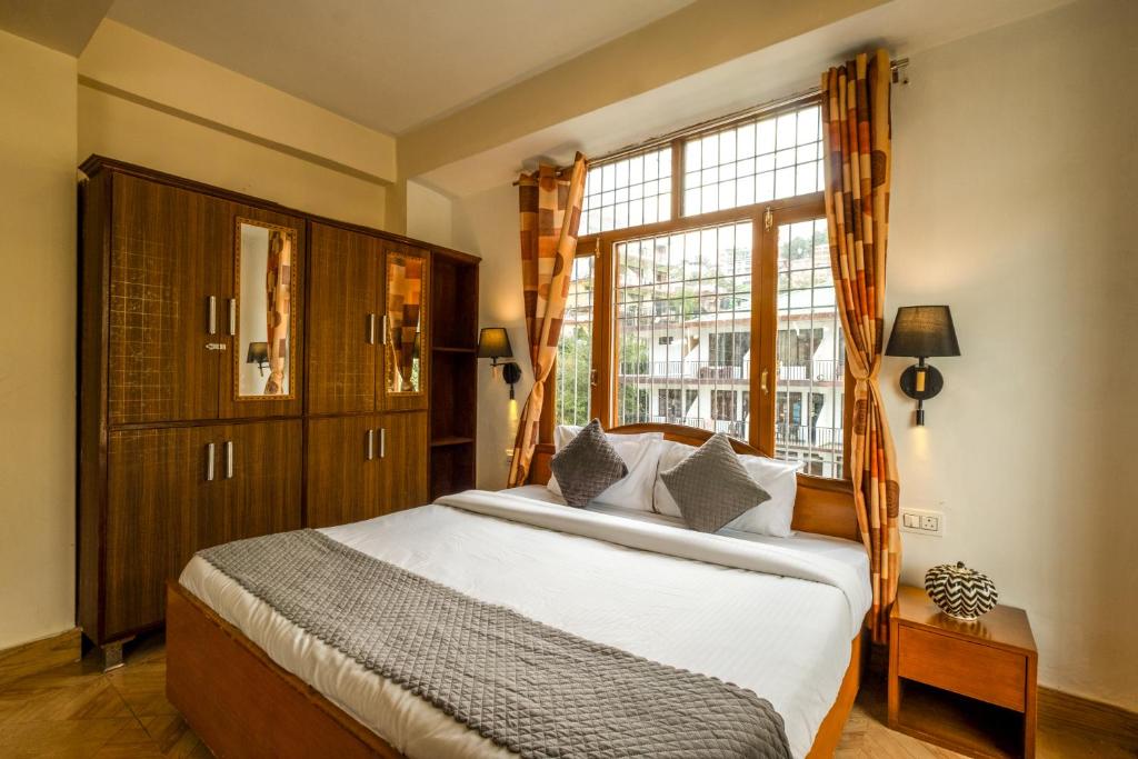 a bedroom with a large bed and a window at Artllers at Vicctoria House, All Mountain View rooms with Free Parking in McLeod Ganj