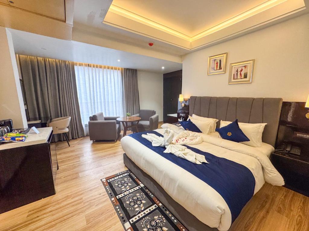 a bedroom with a large bed and a living room at The Fortunaa Avenue in Gwalior