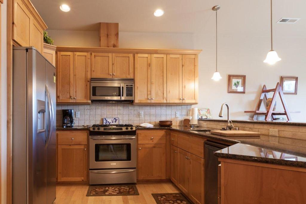 a kitchen with wooden cabinets and stainless steel appliances at River Scene 30 Night Minimum in White Salmon