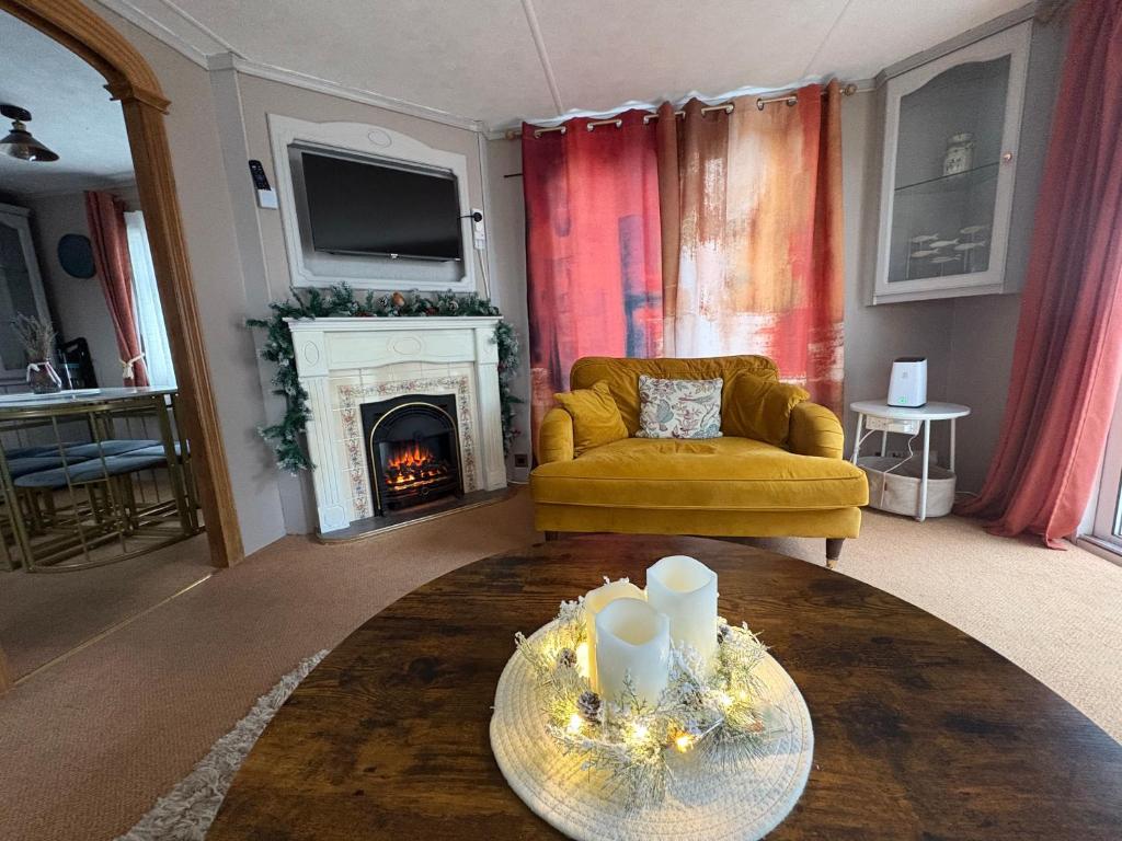 Lytchett MinsterRobins Lodge by the sea的客厅设有黄色沙发和壁炉