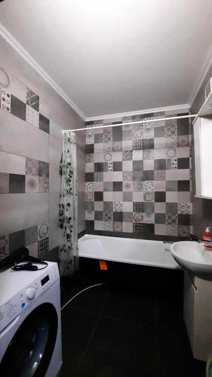 a bathroom with a sink and a washing machine at Двокімнатна квартира з кондиционером документи на відрядження in Poltava