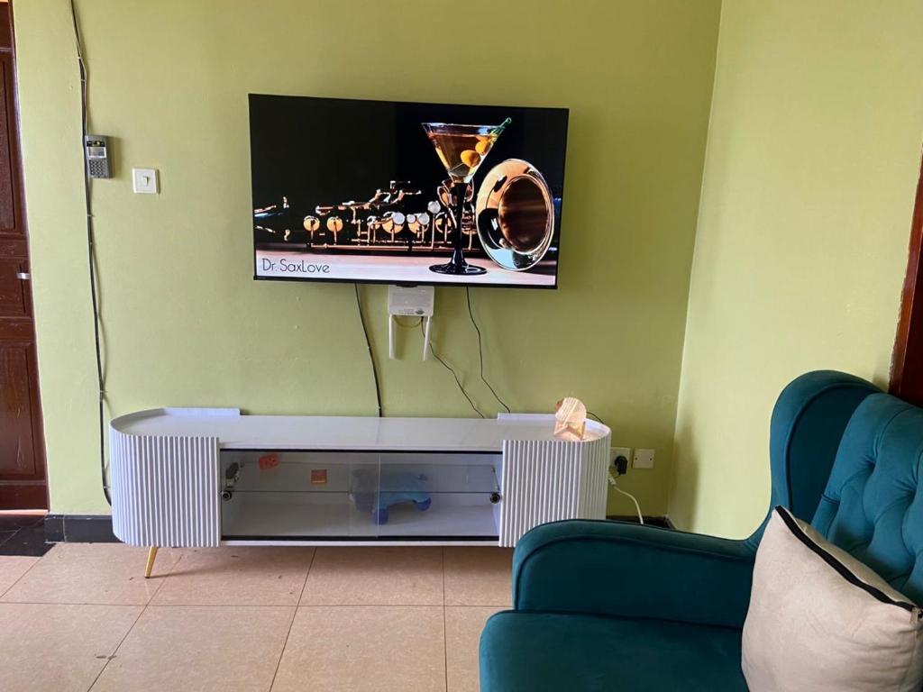 a living room with a tv on a wall at Laala Homes in Kampala