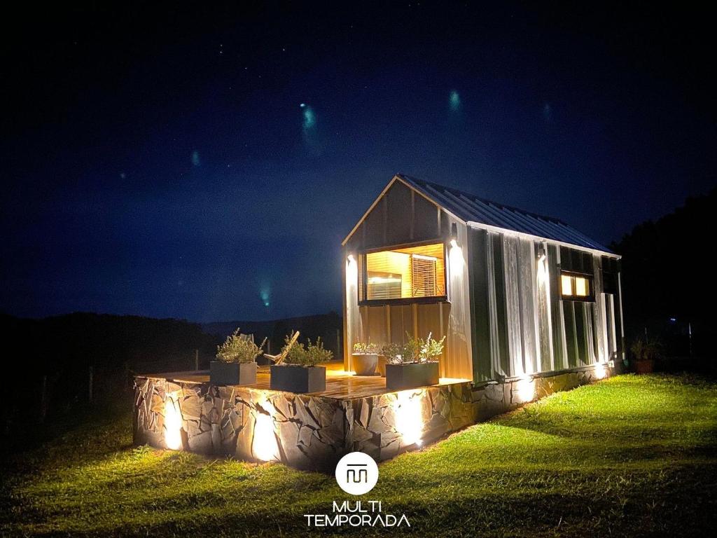 a small house with lights on a lawn at night at Via Kairós - Rancho Queimado - SC in Rancho Queimado