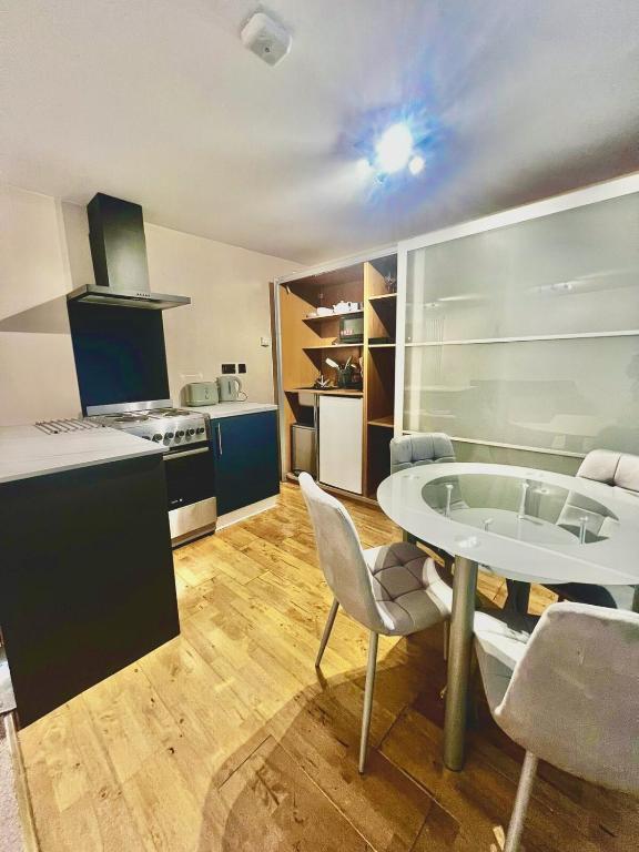 a kitchen with a table and chairs in a room at Dartford Cozy One-Bedroom Flat - Sleeps 2 in Sutton at Hone