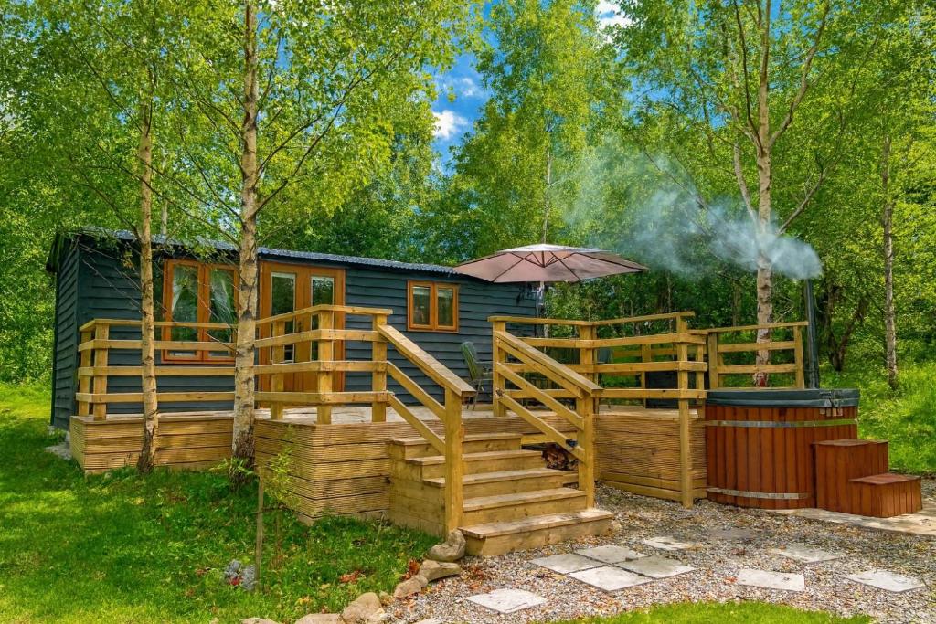 eine Hütte im Wald mit einem Regenschirm in der Unterkunft Martins Meadow Private Wellness Escape in Ballynahinch