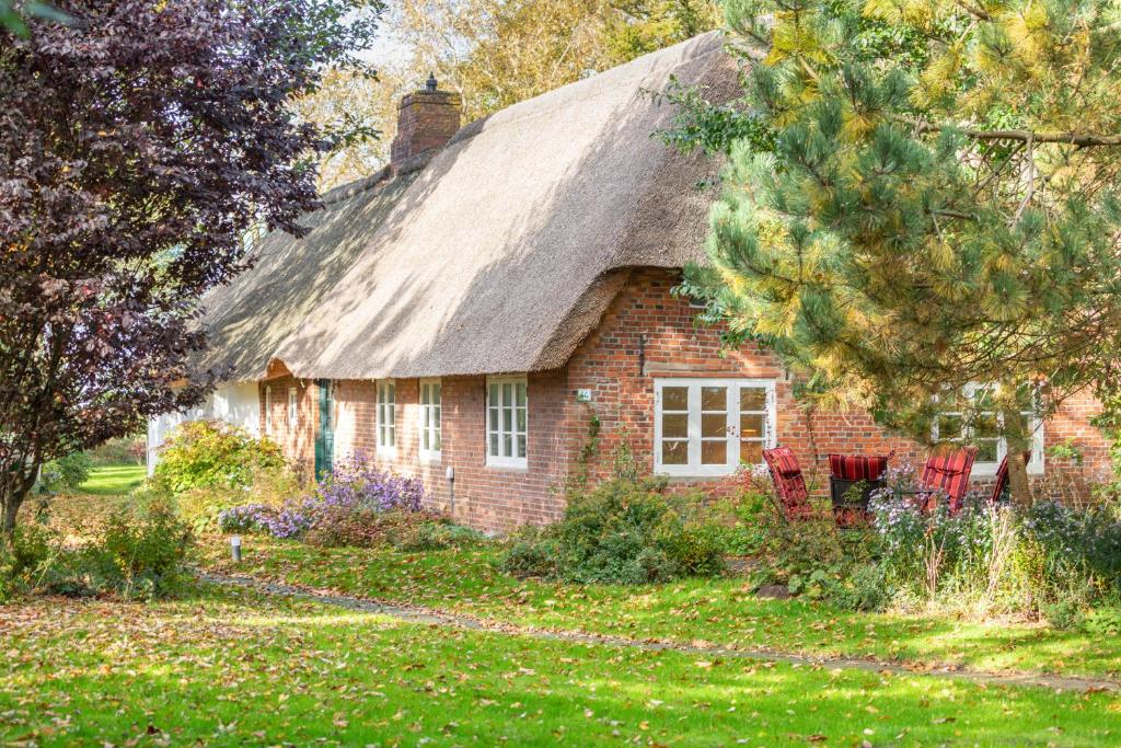 an old brick house with a thatched roof at Reethus Humptrup in Humptrup