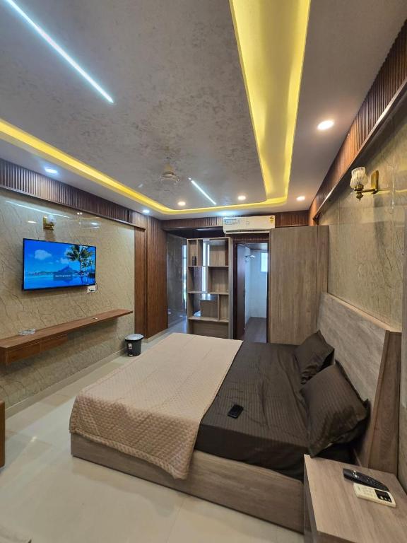 a bedroom with a bed and a tv on a wall at Cozy Studio in Ghaziabad