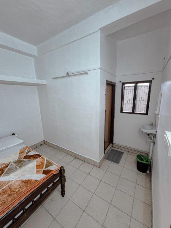 a room with a bed and a sink in it at White stays in Munnar