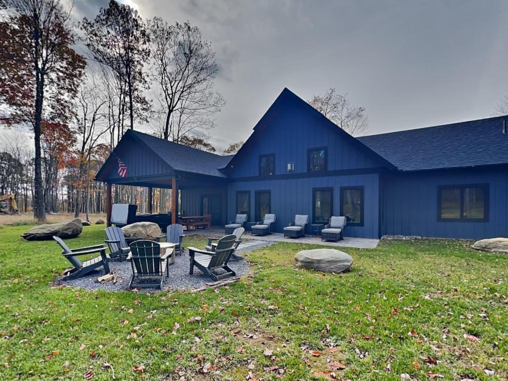 a blue house with chairs and tables in a yard at Mountain Whisper in McHenry