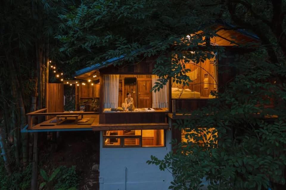 a house with a woman standing in front of it at ทโล้ โฮมสเตย์ เชียงใหม่ | Taloh Homestay Chiangmai in Mae On