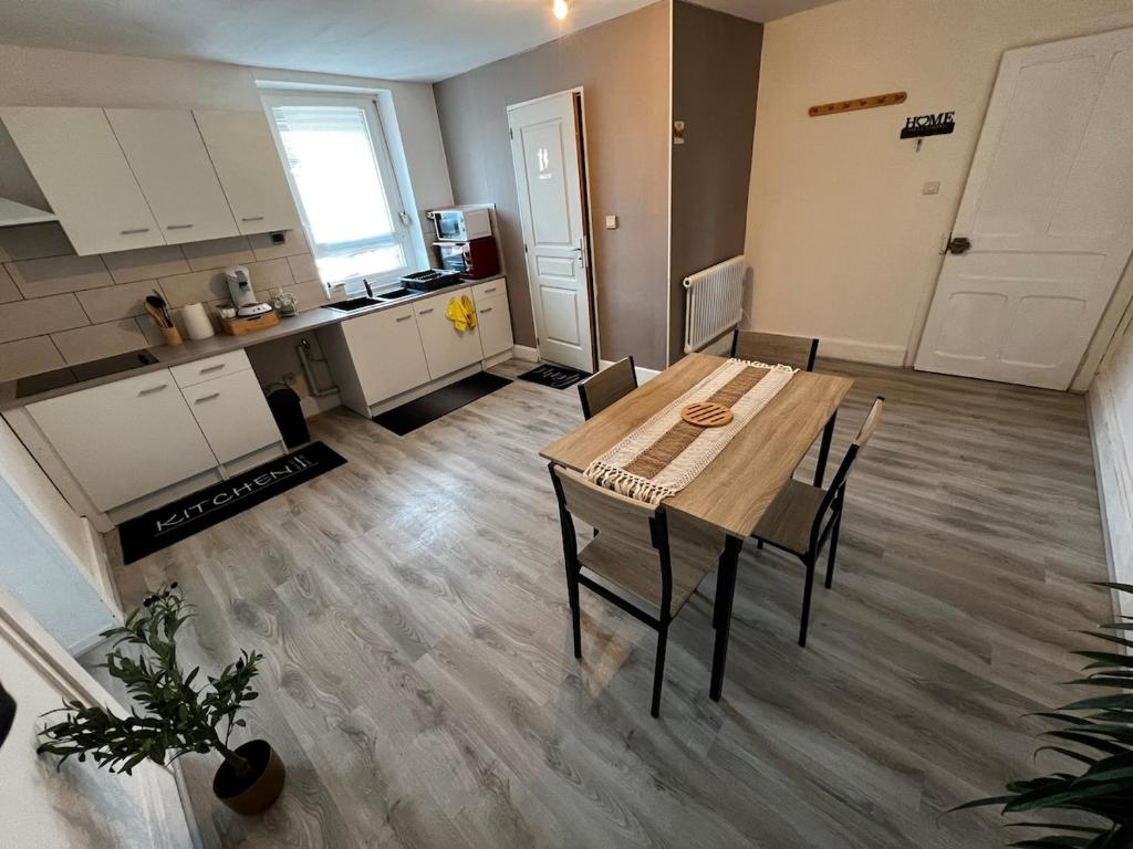 a kitchen and dining room with a table and chairs at appartement au premier étage in Thaon-les-Vosges