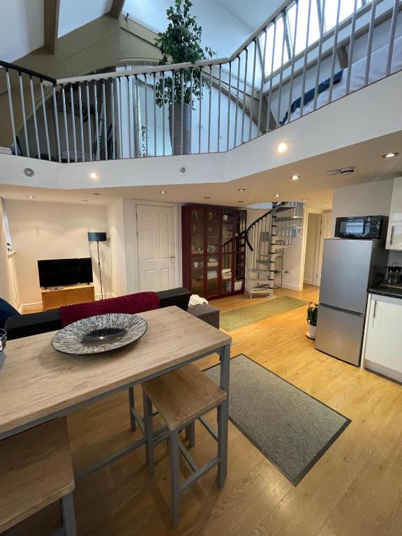 a living room with a table and a kitchen at The Loft St Austell in St Austell