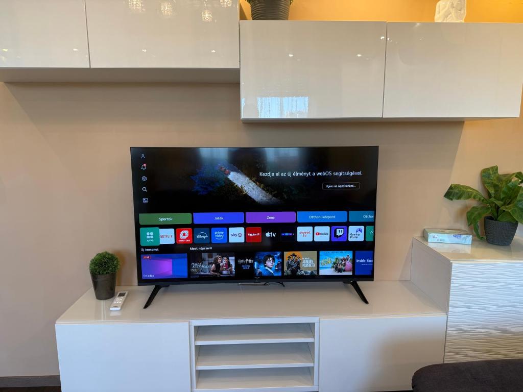 een grote flatscreen-tv aan de muur bij Local-Lux Apartman 3 szoba, privát parkoló in Kecskemét