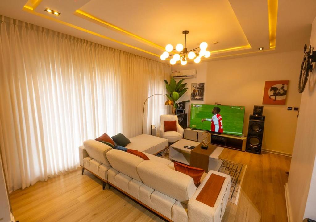 un soggiorno con un divano e una TV di Xentral Luxury 5 star Apartment a Ikate