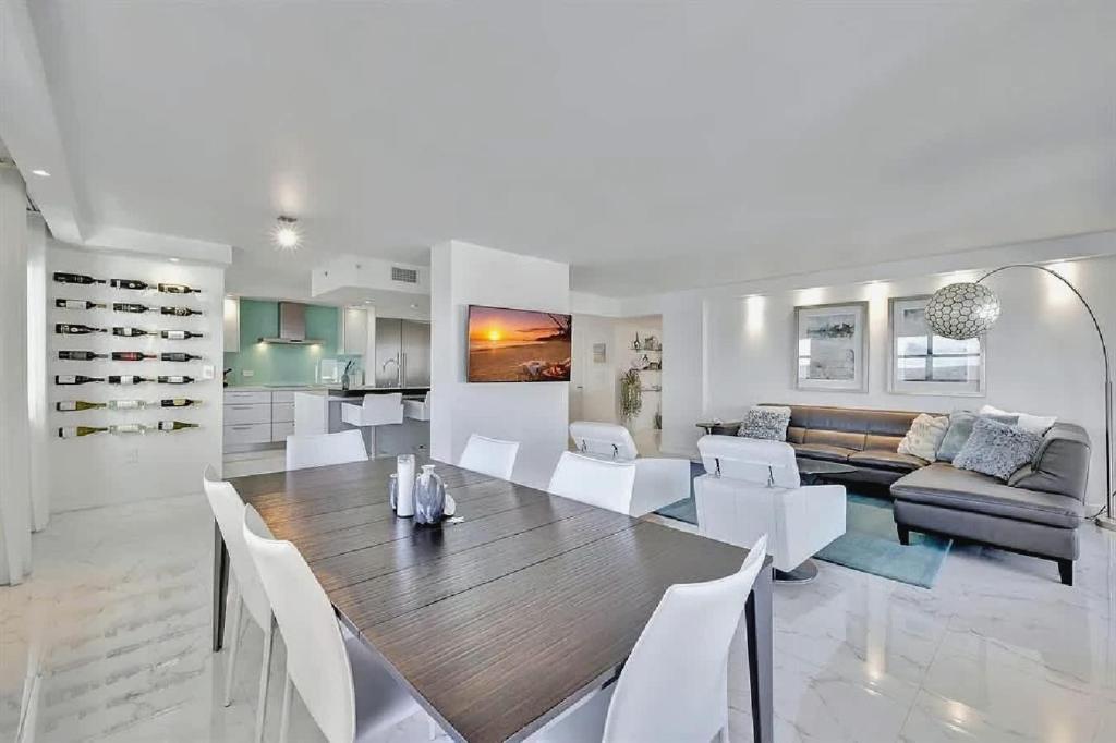 a dining room and living room with a table and chairs at Luxurious Three-Bedroom Oceanfront Apartment with Private Balcony in Hollywood Beach