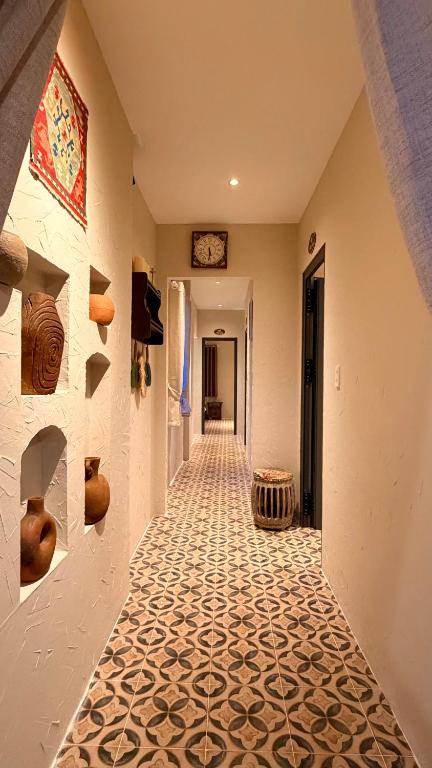 a hallway with a tile floor and a clock on the wall at The Lion Mui Ne in Hòn Lao