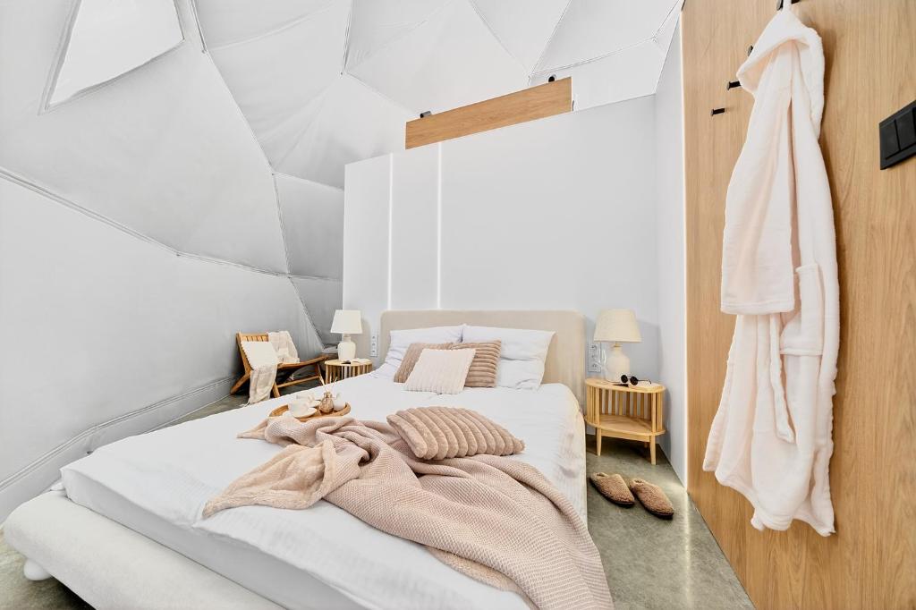 een slaapkamer met een bed met een deken erop bij Sense Resort in Maruszyna