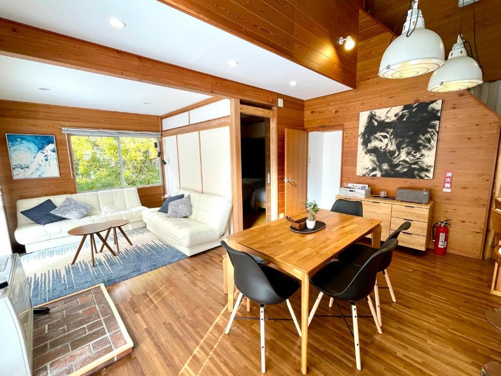 ein Wohnzimmer mit Tisch und Stühlen in der Unterkunft The Black Wolf in Hakuba