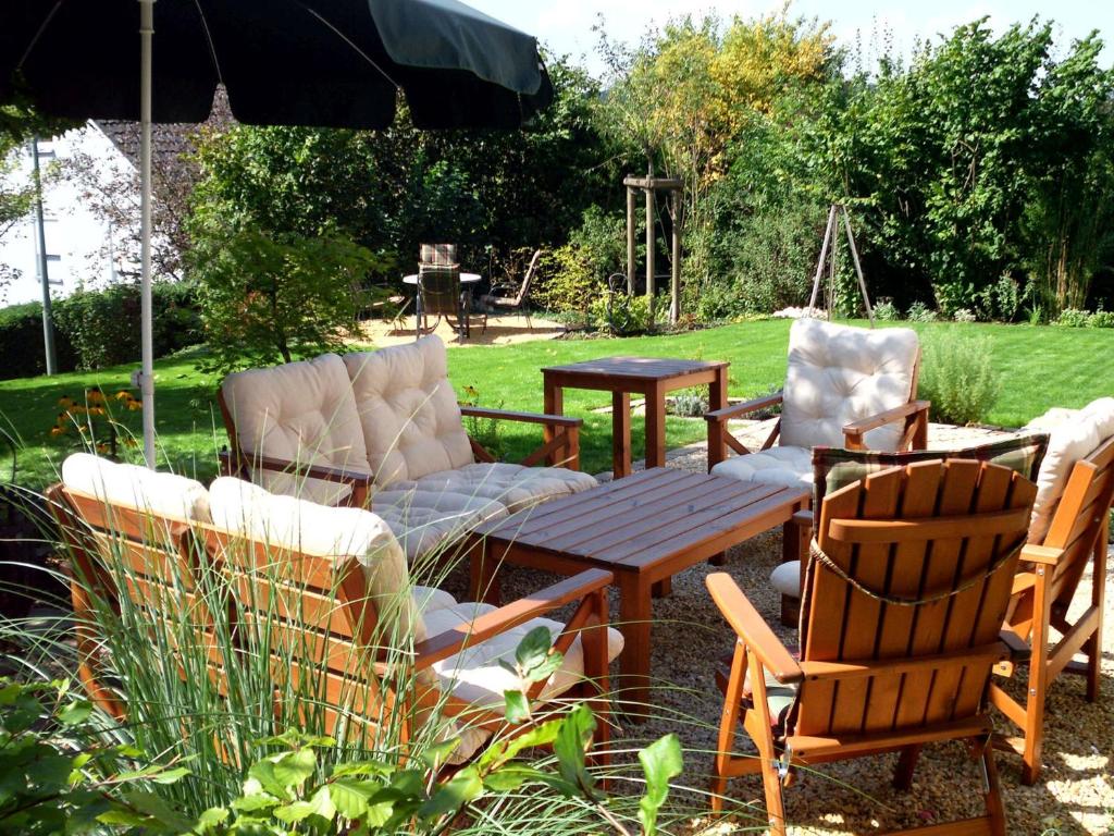 un patio avec des chaises, une table et un parasol dans l'établissement Ferienwohnung Familie Balko, à Herdringen