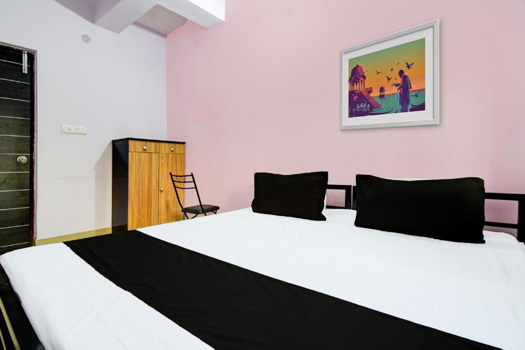 a bedroom with a large white bed and a chair at Super DA Guest Home in Jādabpur