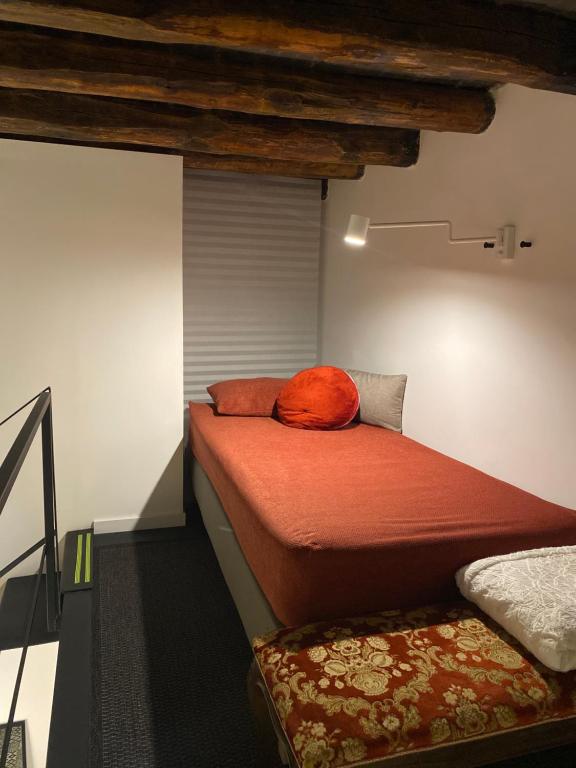 a bedroom with a bed with an orange pillow on it at Casa 3D'Oro Palermo in Palermo